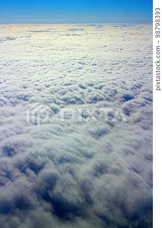 Clouds pass under wing of plane 98798393