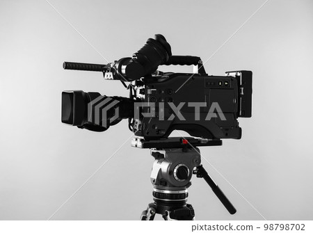 Modern professional video camera on light background Modern professional video camera on light background 98798702