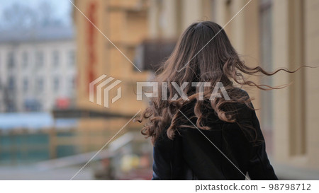 Portrait of a posing happy girl in the city in early spring. Portrait of a posing happy girl in the city in early spring. 98798712