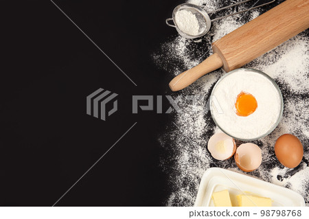 Flat lay composition with eggs and other ingredients on black table, space for text. Baking pie 98798768