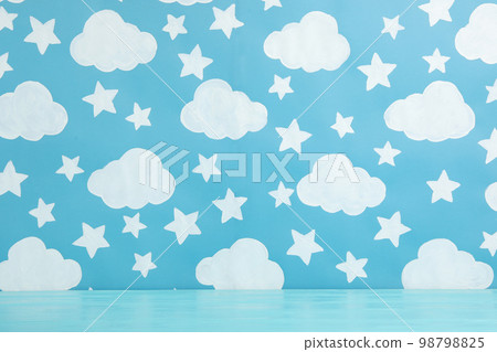 Wooden table near wall with painted blue sky. Idea for baby room interior 98798825
