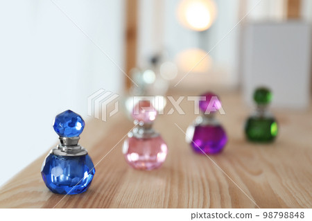 Different perfume bottles on wooden shelf indoors. Space for text 98798848