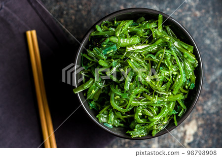 Green seaweed. Japanese wakame salad in bowl. Top view. 98798908