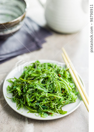 Green seaweed. Japanese wakame salad on plate. Green seaweed. Japanese wakame salad on plate. 98798911