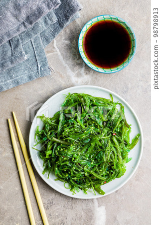 Green seaweed. Japanese wakame salad and soy sauce. Top view. Green seaweed. Japanese wakame salad and soy sauce. Top view. 98798913
