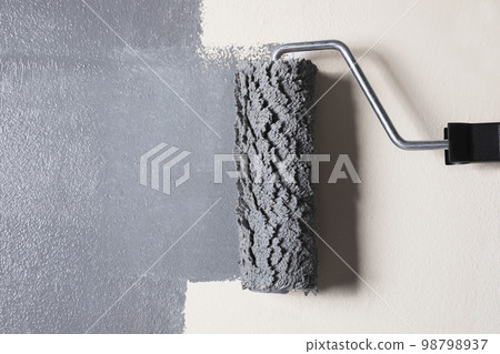 Painting beige wall with grey dye, closeup view Painting beige wall with grey dye, closeup view 98798937