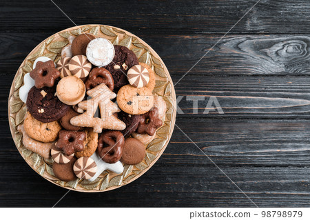 Delicious cookies in plate on black wooden table, top view. Space for text 98798979