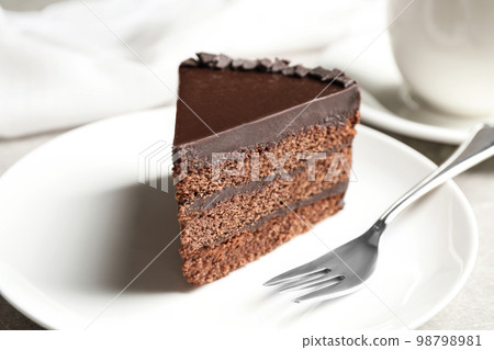 Piece of tasty chocolate cake served on plate 98798981