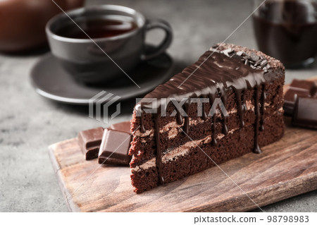Piece of delicious chocolate cake on grey table 98798983