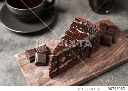 Piece of delicious chocolate cake on grey table Piece of delicious chocolate cake on grey table 98798985