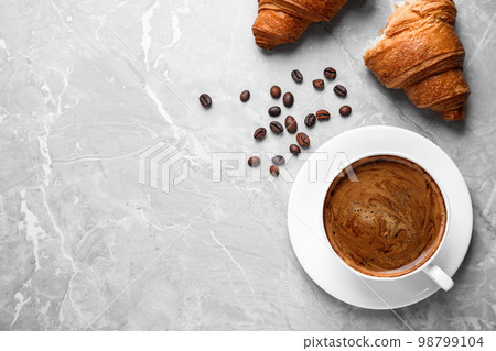 Tasty fresh croissants and coffee on light grey marble table, flat lay. Space for text 98799104