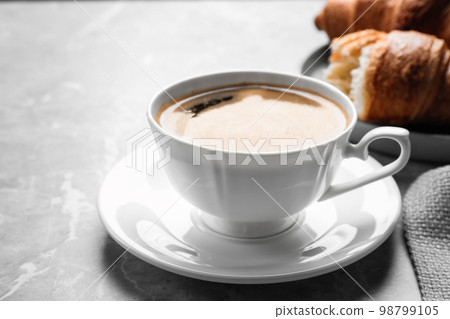 Coffee and tasty croissants on light grey marble table, closeup 98799105
