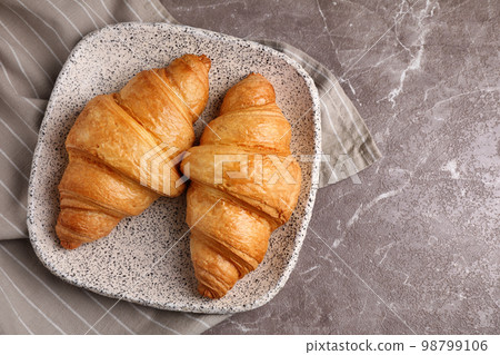 Tasty fresh croissants on brown marble table, flat lay. Space for text Tasty fresh croissants on brown marble table, flat lay. Space for text 98799106
