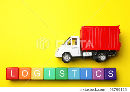 Flat lay composition with toy truck and word LOGISTICS on yellow background, space for text. Wholesale concept Flat lay composition with toy truck and word LOGISTICS on yellow background, space for text. Wholesale concept 98799113