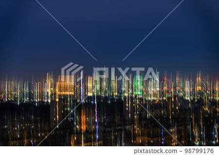 Blurred skyscrapers against dark sky, buildings at night, Illuminated windows. Modern neon city Blurred skyscrapers against dark sky, buildings at night, Illuminated windows. Modern neon city 98799176