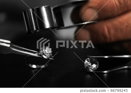 Professional jeweler working with beautiful ring at table, closeup 98799245