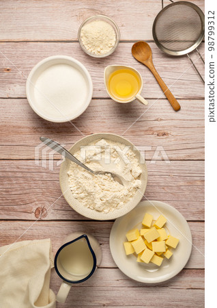 Baking cooking food ingredients, eggs, flour, butter, oil and milk. Top view, rustic wooden background Baking cooking food ingredients, eggs, flour, butter, oil and milk. Top view, rustic wooden background 98799312