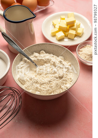 Close up flour in bowl with baking tools and ingredients. Sugar, milk, butter, eggs. Close up flour in bowl with baking tools and ingredients. Sugar, milk, butter, eggs. 98799327
