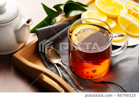 Black tea and lemon slice. Tea time, wooden background Black tea and lemon slice. Tea time, wooden background 98799328