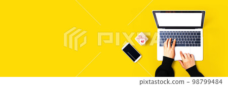 Person using a laptop computer with a small gift box Person using a laptop computer with a small gift box 98799484