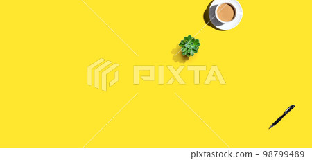 A cup of coffee and and a pen on an open writing desk 98799489
