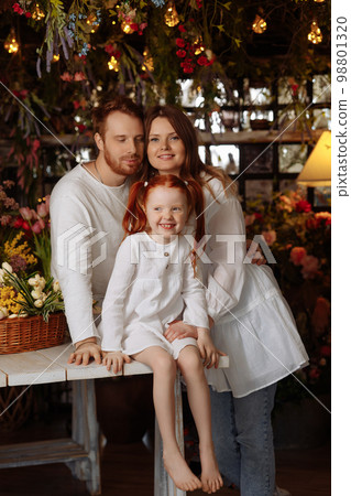 Family of three, consisting of a father, mother and their little red-haired daughter Family of three, consisting of a father, mother and their little red-haired daughter 98801320