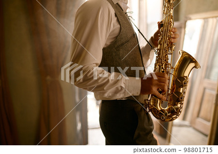 Cropped shot of unrecognizable male musician playing his saxophone at home 98801715