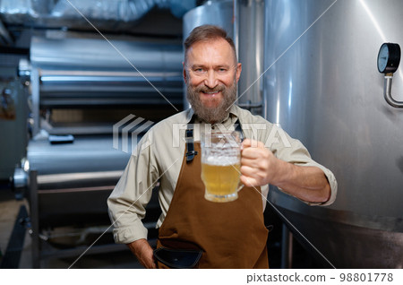 Freshly made craft beer in brewery worker hand, selective focus Freshly made craft beer in brewery worker hand, selective focus 98801778