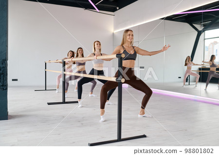 Young smiling female group doing stretching at pilates studio 98801802