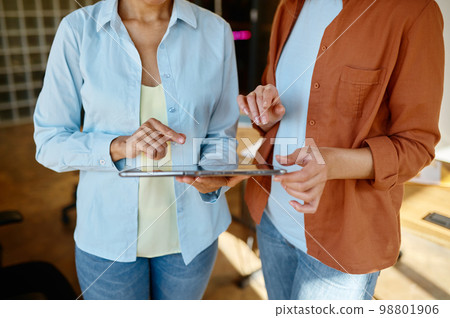 Female coworkers planning strategy on digital tablet at coworking office Female coworkers planning strategy on digital tablet at coworking office 98801906