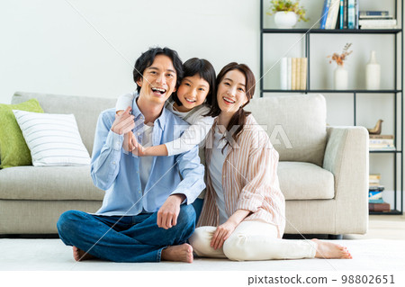 A young family relaxing in the living room A young family relaxing in the living room 98802651