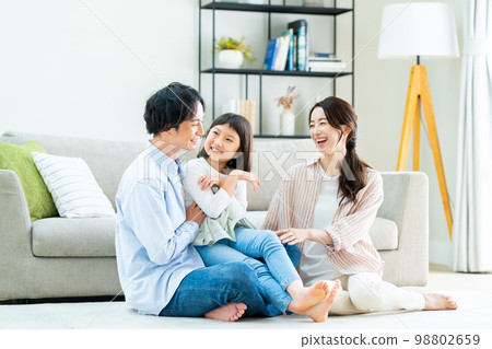 A young family relaxing in the living room A young family relaxing in the living room 98802659