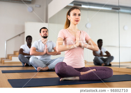 People exercising lotus asana in gym 98802710