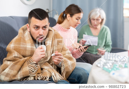 Sick man sitting with wife and mother Sick man sitting with wife and mother 98802723