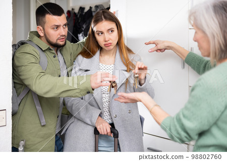 Dissatisfied owner receiving keys from married couple tenants Dissatisfied owner receiving keys from married couple tenants 98802760