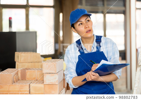 Portrait of an asian builder woman who checks completed work on 98802783