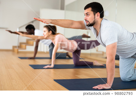 Bearded man standing in balancing asana Dandayamna Bharmanasana Bearded man standing in balancing asana Dandayamna Bharmanasana 98802793