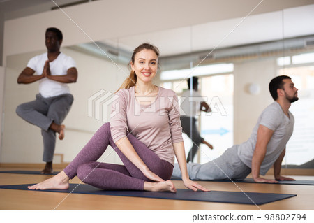 Woman sitting in lord of the fishes pose, group training Woman sitting in lord of the fishes pose, group training 98802794