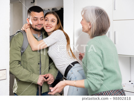 Family welcoming and embracing man who came after work trip 98802818