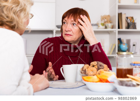 Upset mature lady having unpleasant talk with female 98802869