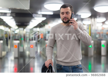 Portrait of man passing faregate on subway station 98802888