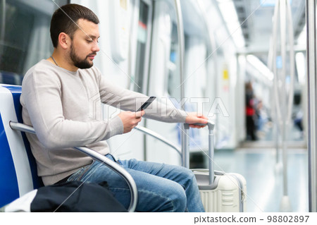 Portrait of european man standing in underground carriage and using phone Portrait of european man standing in underground carriage and using phone 98802897