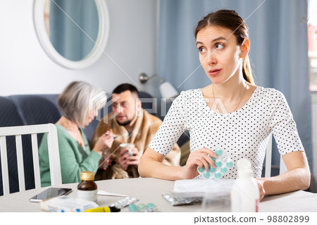 Woman thinking about treatment for her ill husband at home Woman thinking about treatment for her ill husband at home 98802899