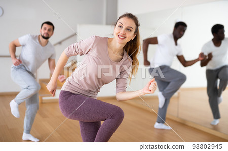 Young woman learning dynamic dances in choreography class Young woman learning dynamic dances in choreography class 98802945