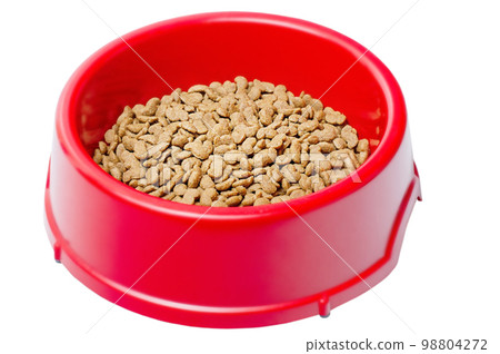 Dry food for pet cats or dogs in a red bowl. Balanced food for animals isolate on white. 98804272