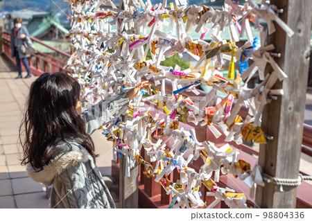 Photo of a girl looking at an omikuji Photo of a girl looking at an omikuji 98804336