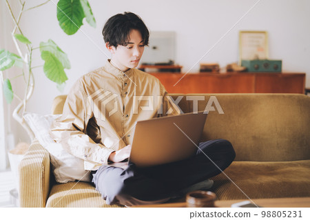 在沙發上使用電腦的男人 98805231