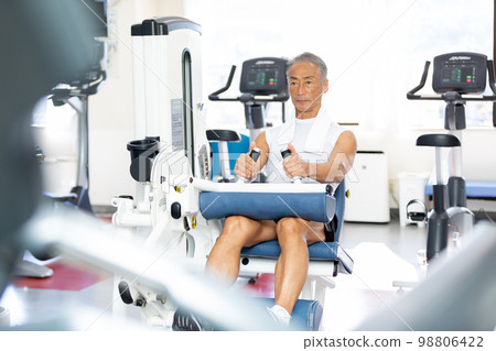 老人在健身房用腿部伸展鍛煉股四頭肌 老人在健身房用腿部伸展鍛煉股四頭肌 98806422