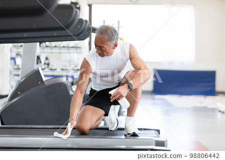 一位彬彬有禮的老人對用過的訓練機進行清潔和消毒 98806442