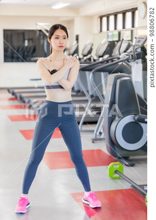 蹲在體育館裡的年輕女子 98806782